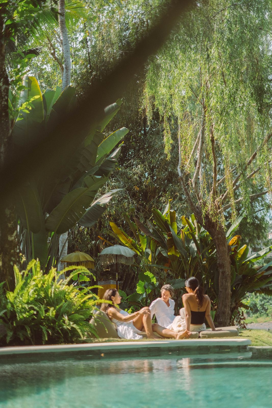 Retreat guests resting together by the pool in the Bali jungle