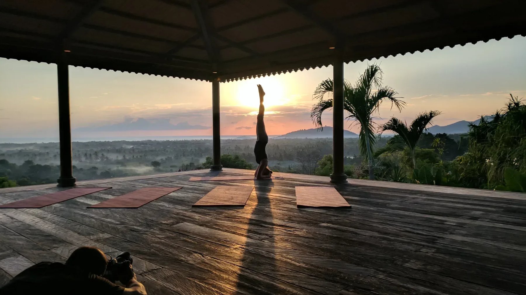 Sunrise headstand on an open yoga deck over the Bali jungle